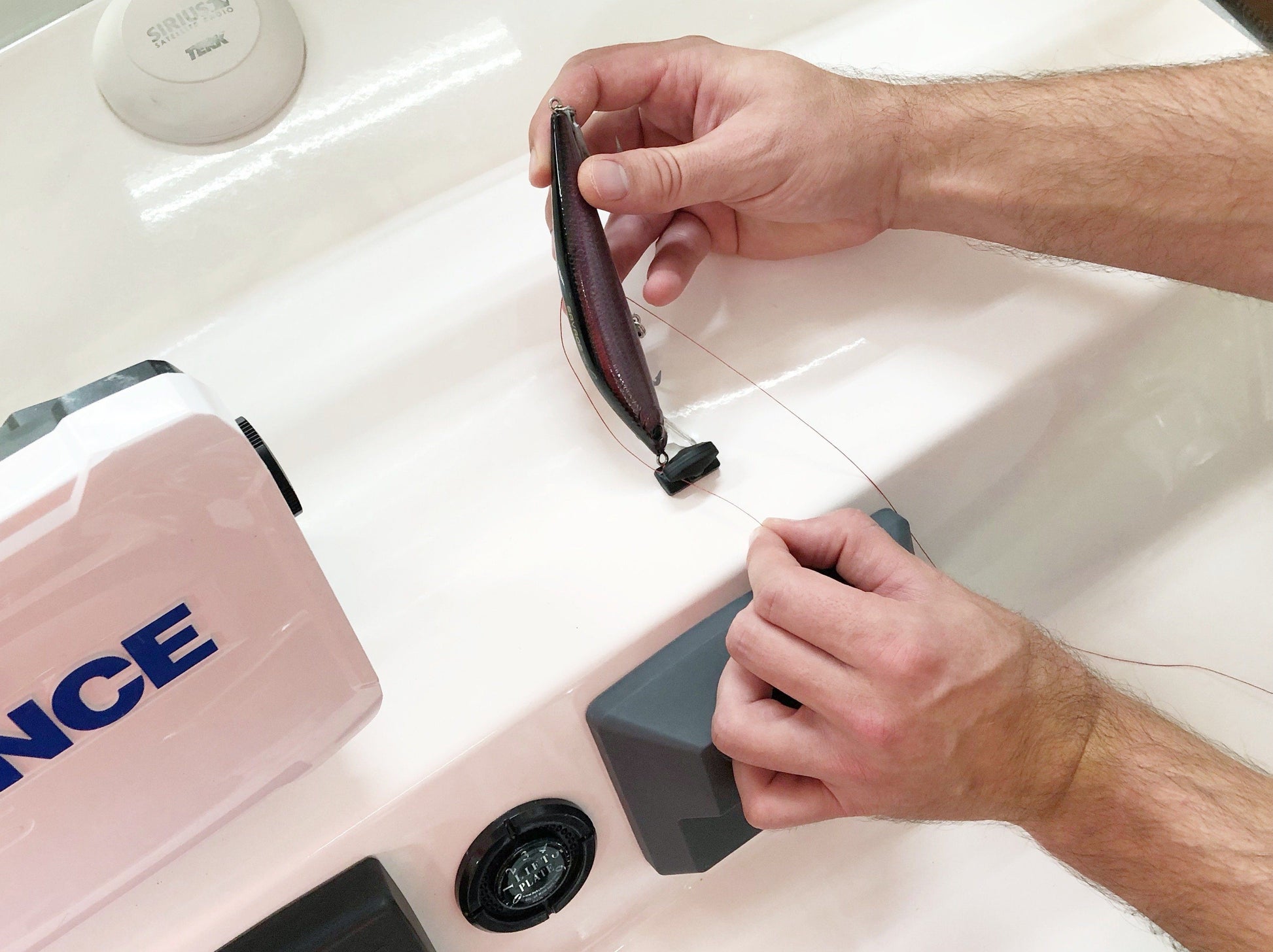 Line Cutterz Ceramic Blade Peel & Stick Flat Mount being used to cut a line around a lure while mounted