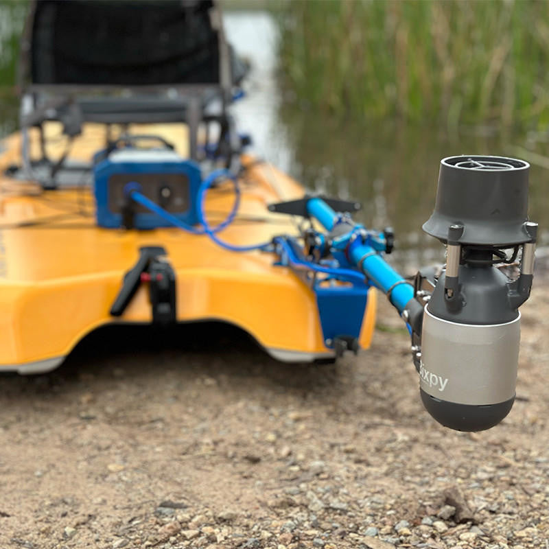 Close-up of Bixpy Jet Motor attached to a kayak, showing the motor, power cable, and battery pack on the kayak's deck.