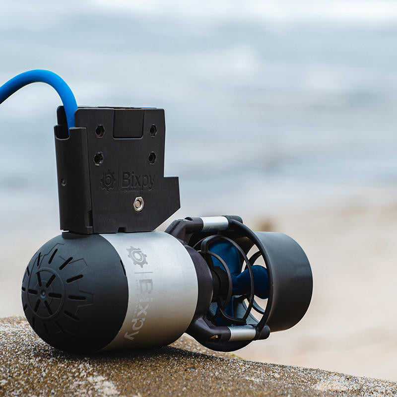 Bixpy Jet Motor: Close-up view of the motor and mounting bracket on a beach.