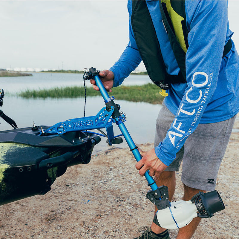 Angler installing a Bixpy Jet Motor onto a kayak using a blue Power-Pole adapter.