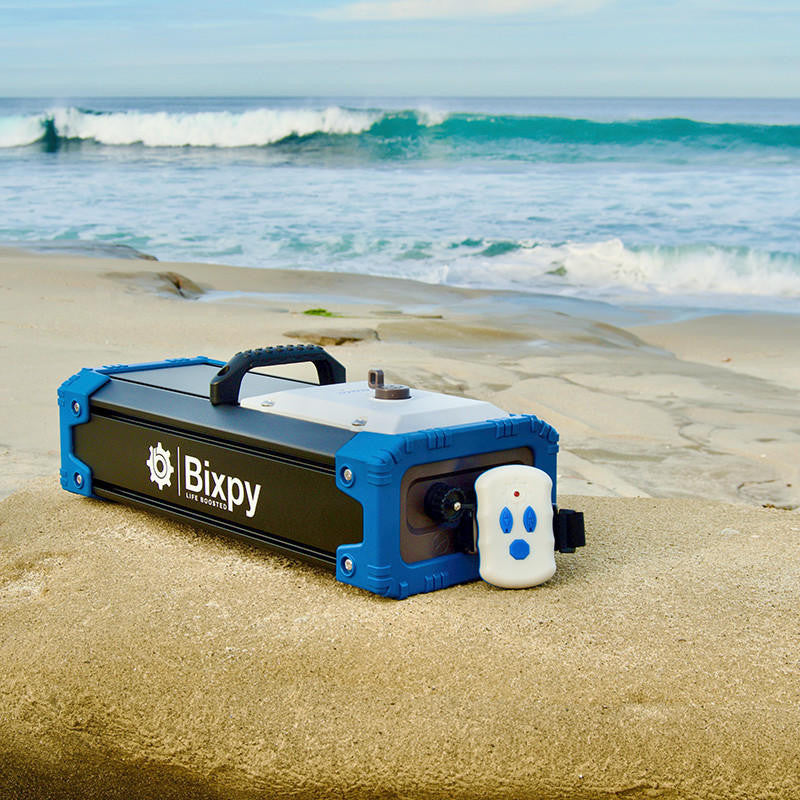 Bixpy portable power unit and wireless remote control on the beach.