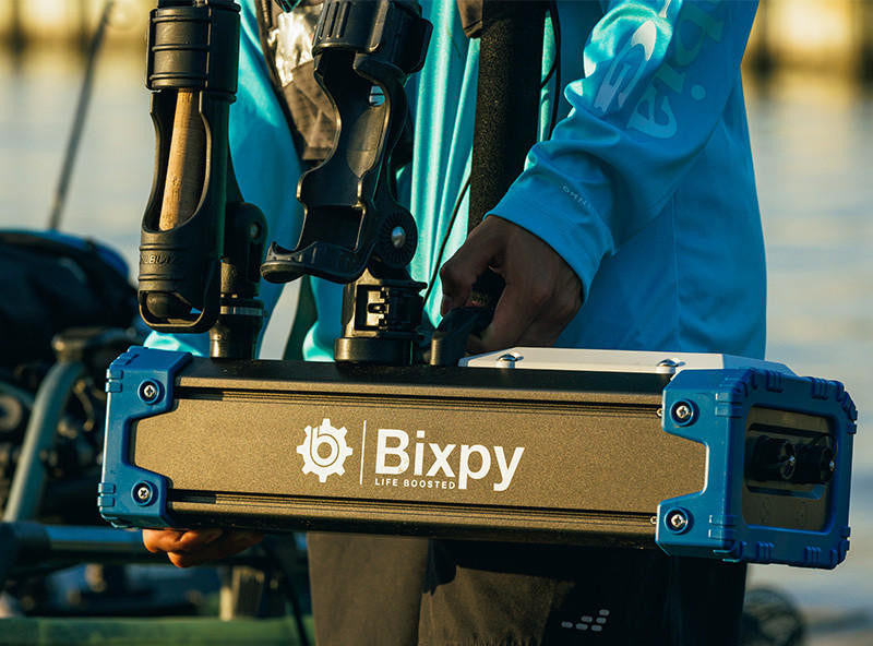 Bixpy Outboard Kit: Angler holding the Bixpy unit, showcasing its compact size and integrated mounting system.