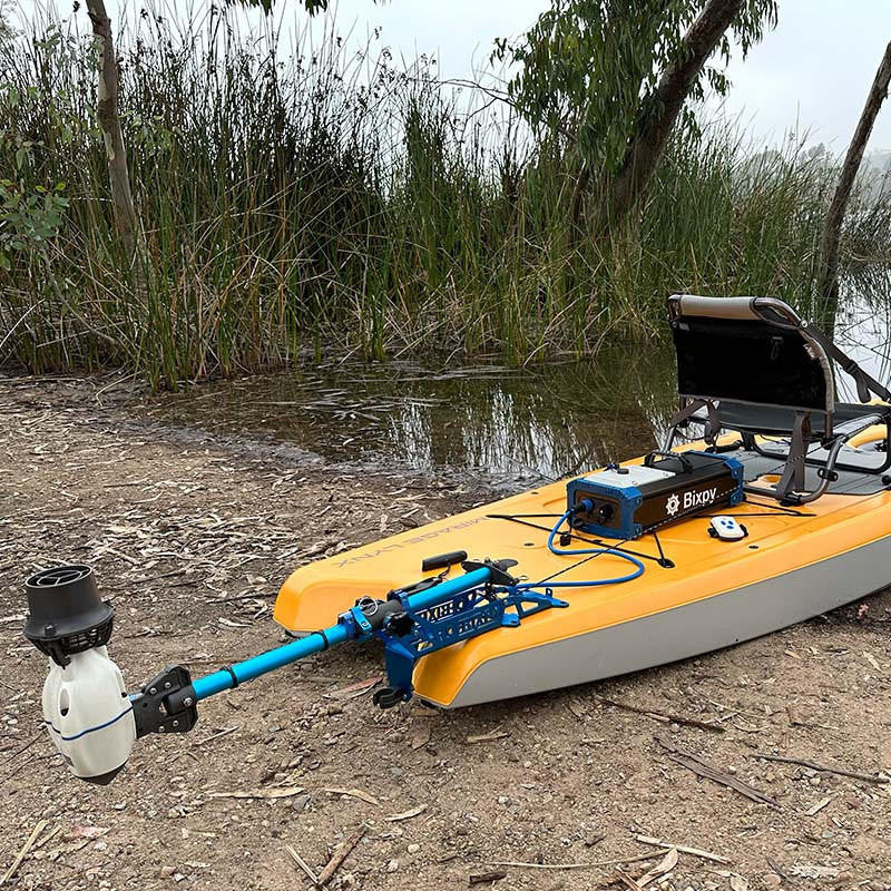 Bixpy Jet Motor and Battery Pack installed on a kayak near the shore of a lake.