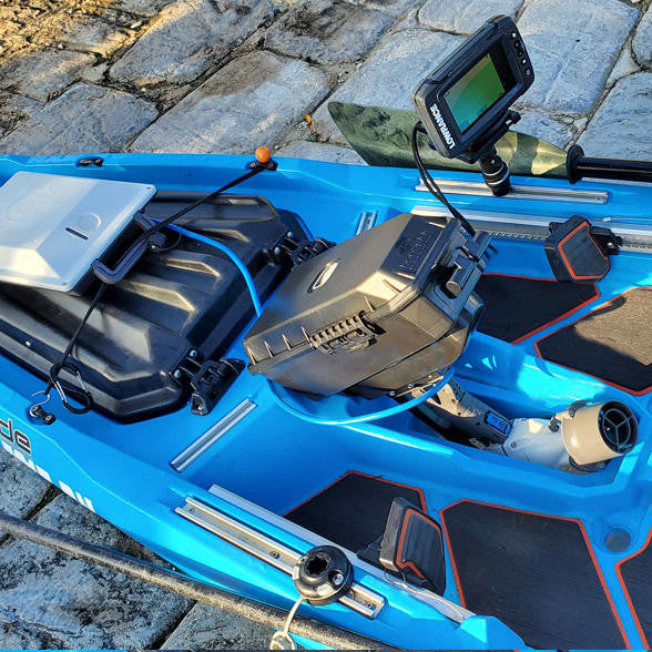 Bonafide Pod Adapter with Bixpy J-1 Motor installed in blue Bonafide kayak cockpit, shown with fish finder, gear tracks, and mounted electronics for fishing setup.