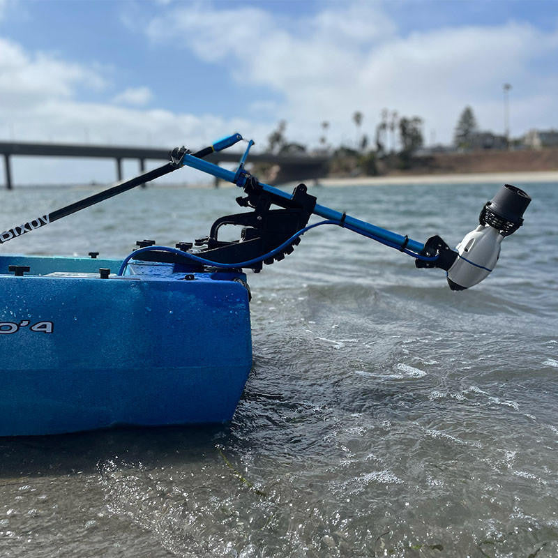 Blue kayak in shallow water propelled by a white Bixpy Jet electric motor mounted on a blue and black universal transom mount.