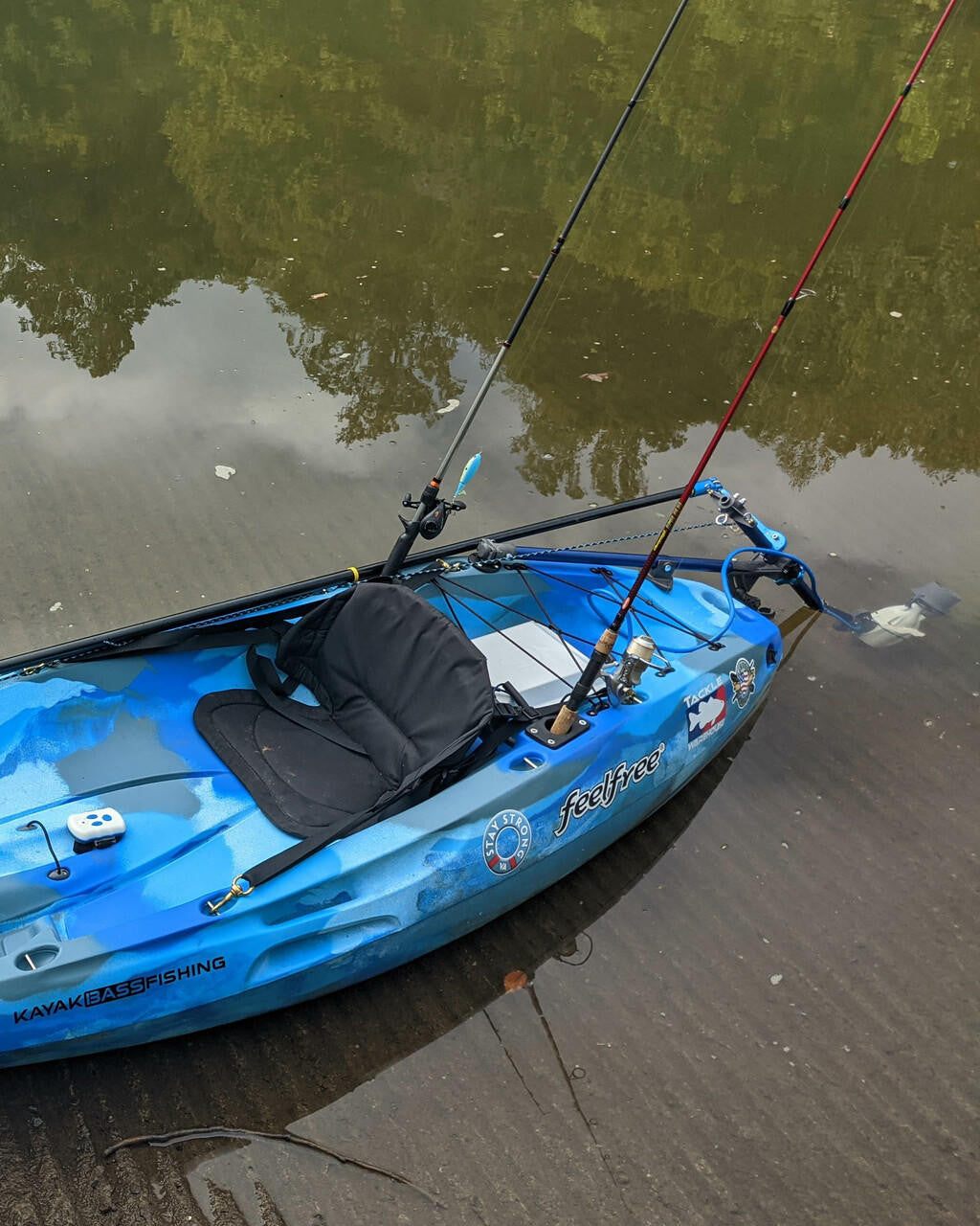 Blue camouflage Feelfree fishing kayak with Bixpy Universal Kayak Adapter and two fishing rods.