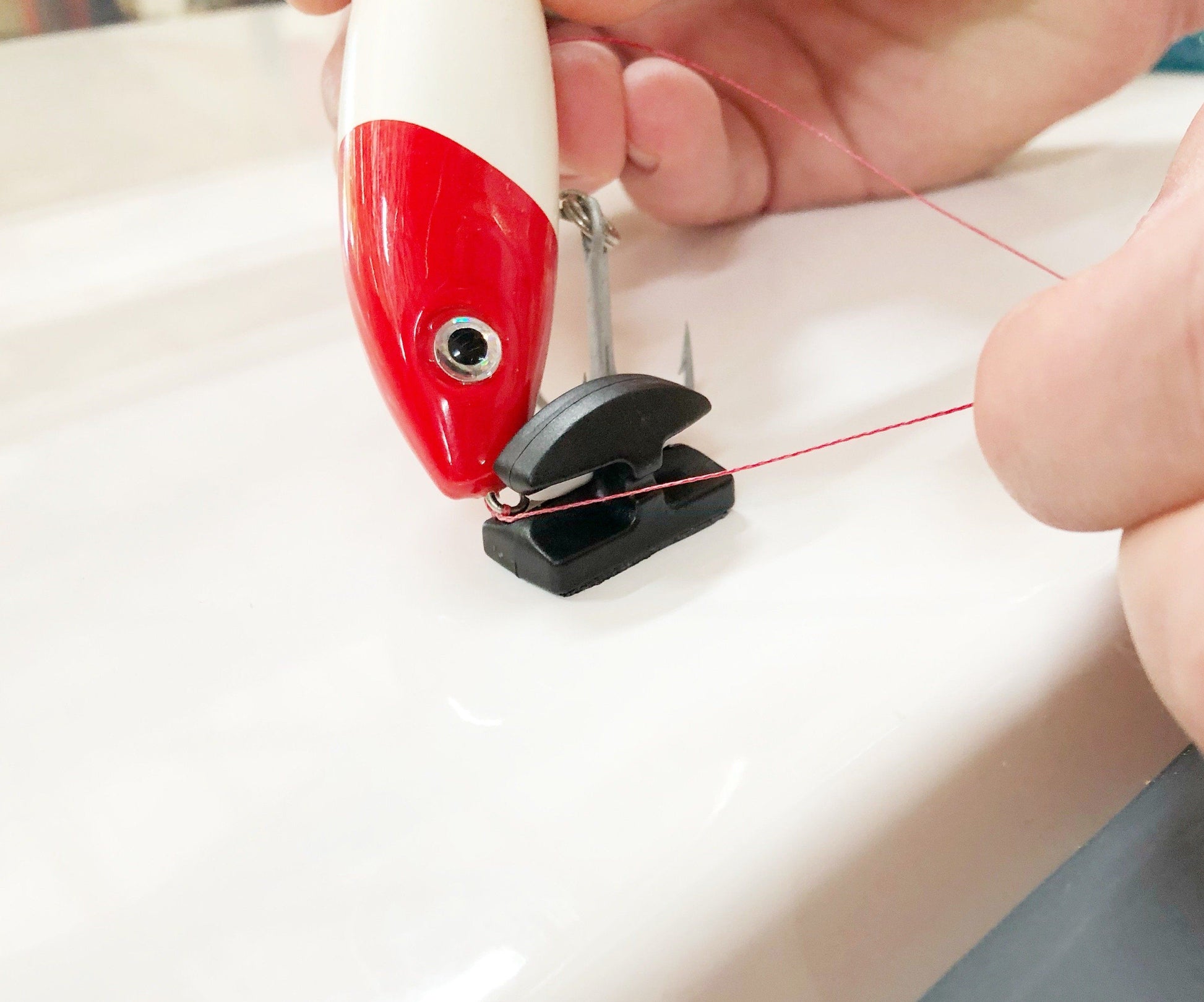 Line Cutterz Ceramic Blade Peel & Stick Flat Mount being used to cut a line around a lure