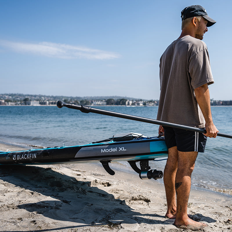Man holding paddleboard with Flip & Lock Fin Bundle