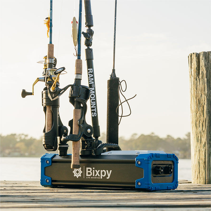 Fishing rods are mounted on a Bixpy battery pack on a dock.