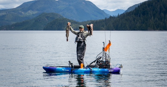 Man stands in Vibe Makana 100 with two fish