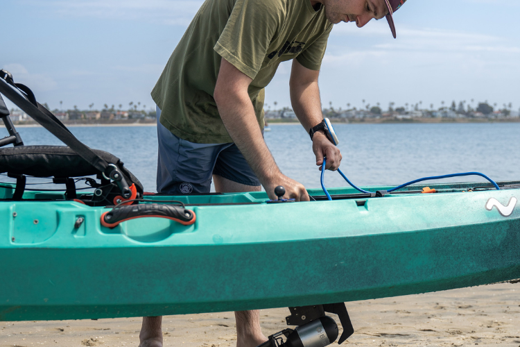 Man inspects cords on personal watercraft to ensure the Bixpy motor is attached properly
