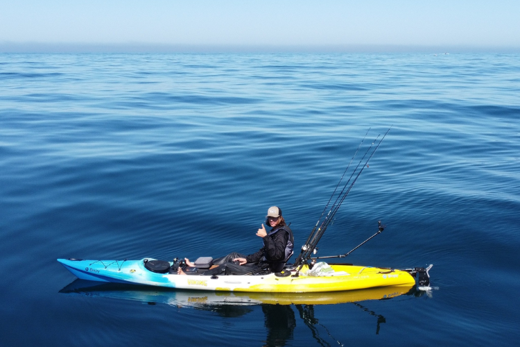 Man in a kayak on his way to go fishing in the blue ocean using a Bixpy motor