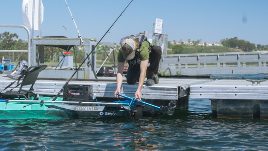 a male adjusting Bixpy K-1 motor on a kayak