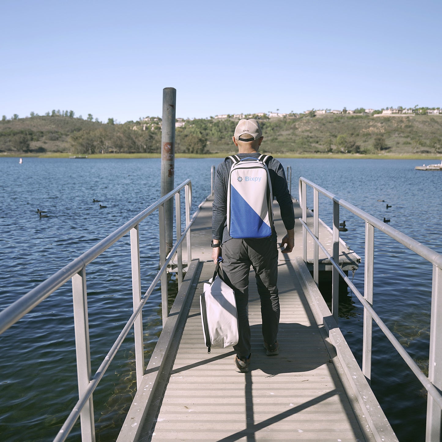 a man carrying n-3 motor battery backpack and shaft bag