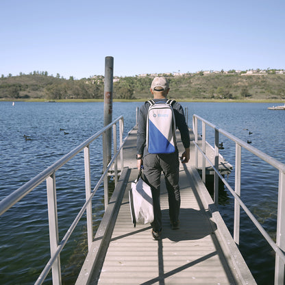 a man carrying n-3 motor battery backpack and shaft bag