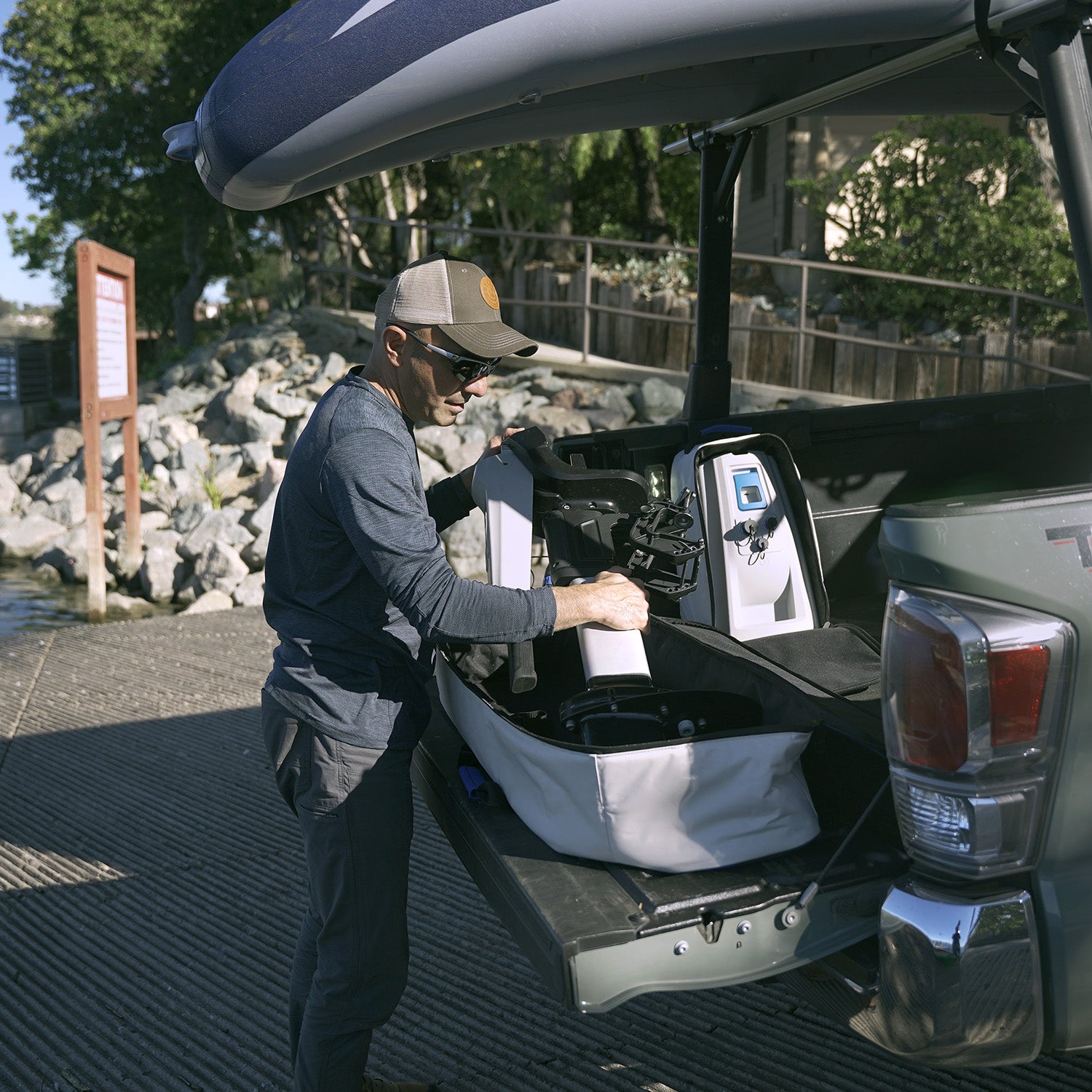 a man putting n-3 motor assembly into a bag in the back of a pick up truck