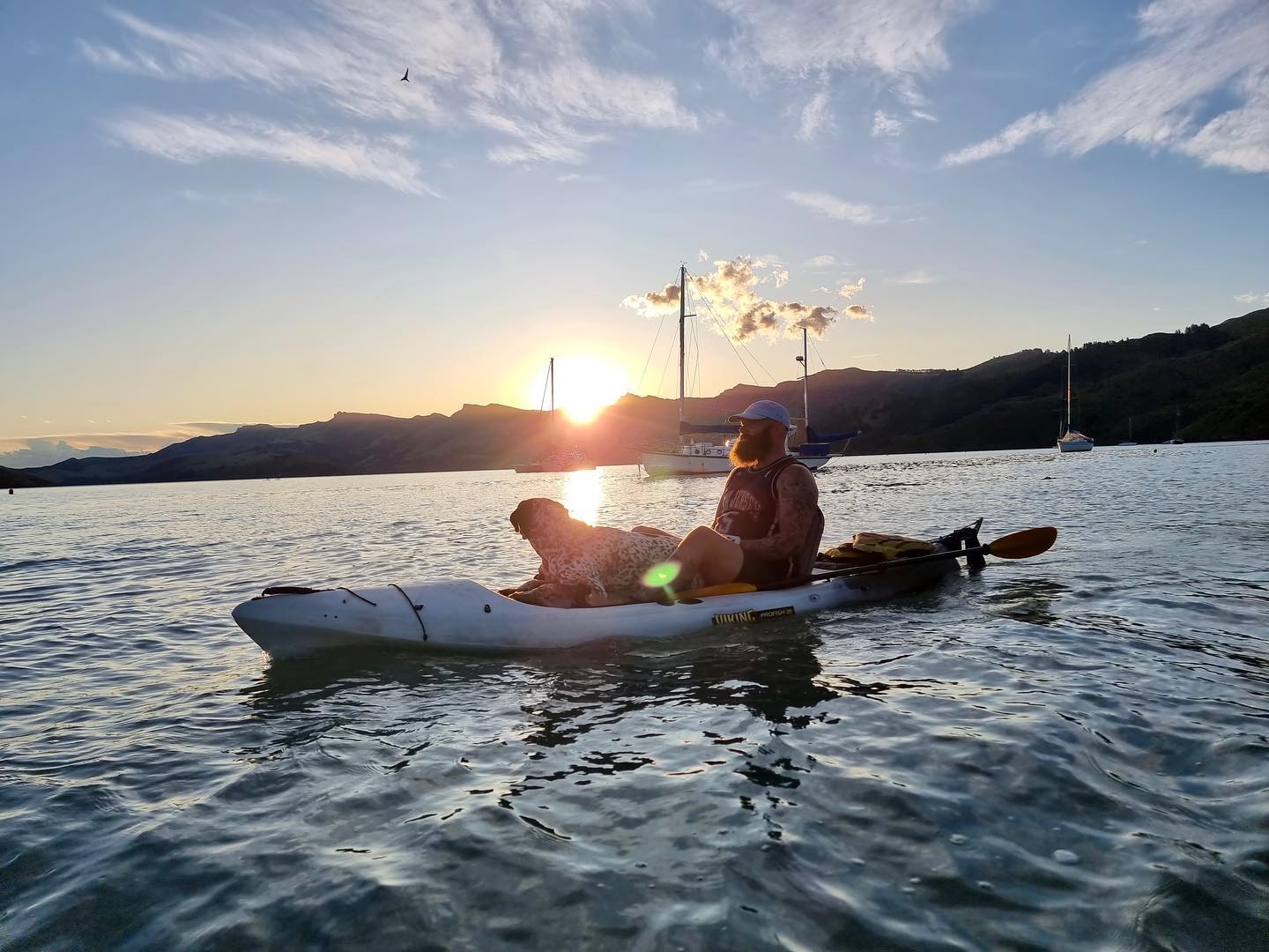 Man with dog sitting in kayak powered by a Bixpy motor
