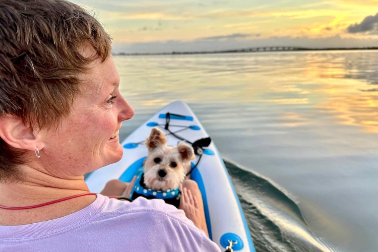 Woman in boat with yorkie, boat powered by a Bixpy motor