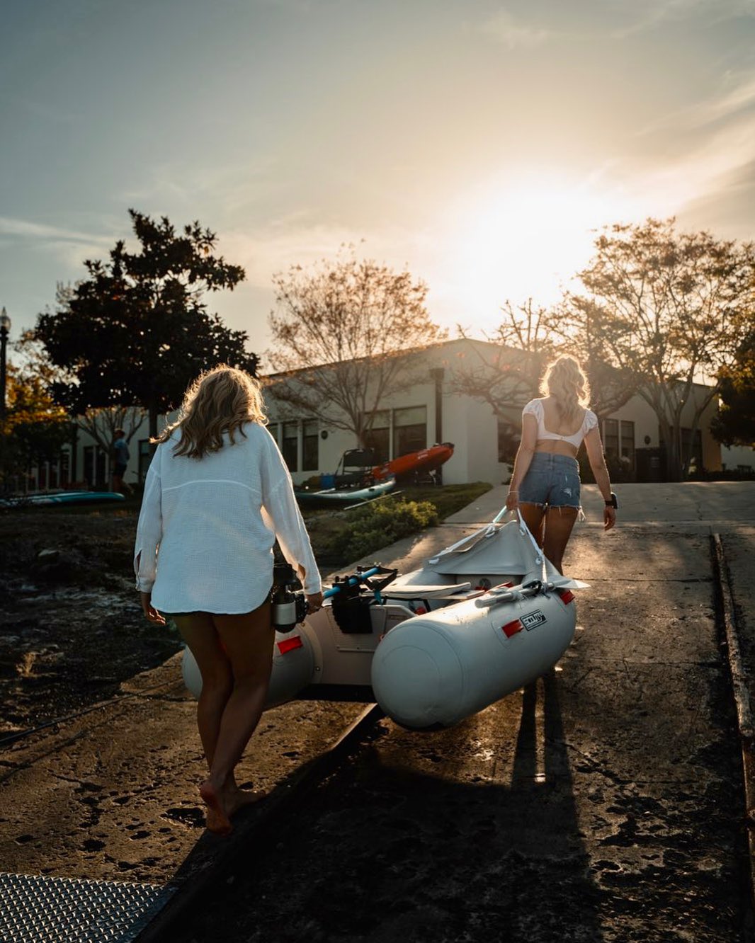 Two women carry inflatable boat featuring Bixpy motor