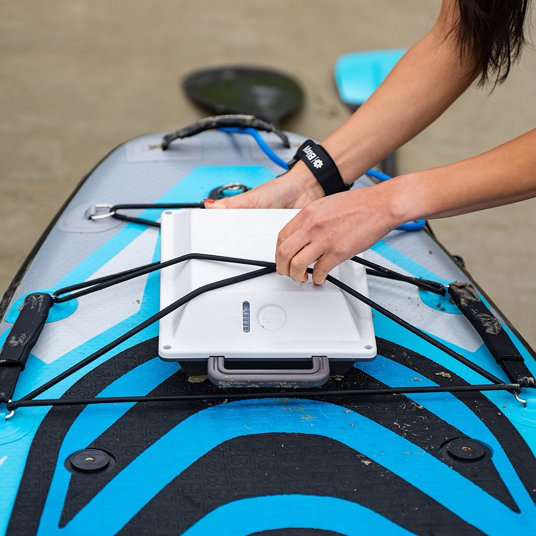 Woman puts Bixpy battery on paddleboard