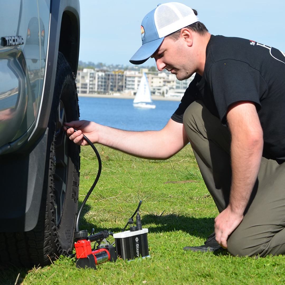 Man using Bixpy power bank to fill up air in tire