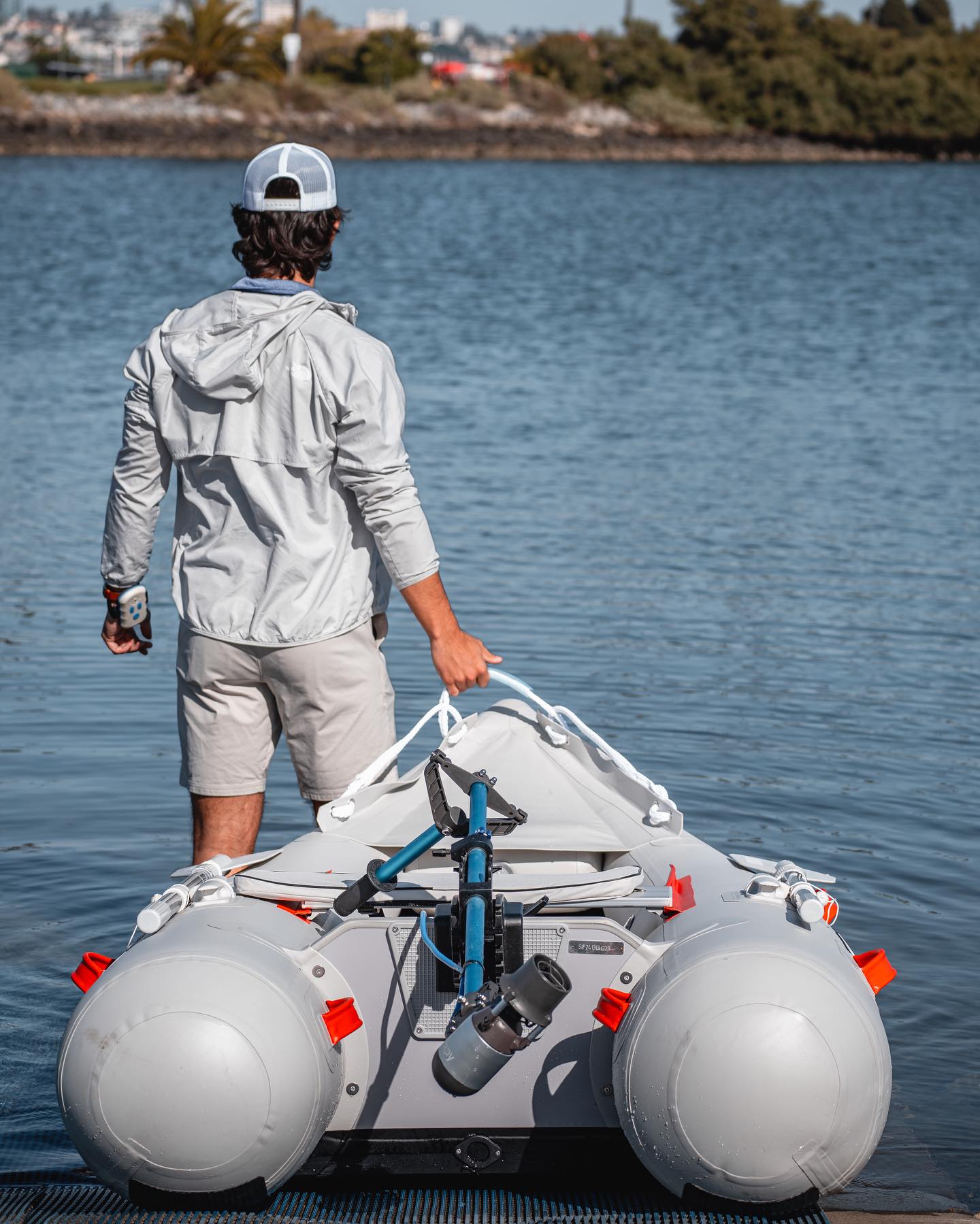 Man hauling inflatable boat to the water with a Bixpy motor on it