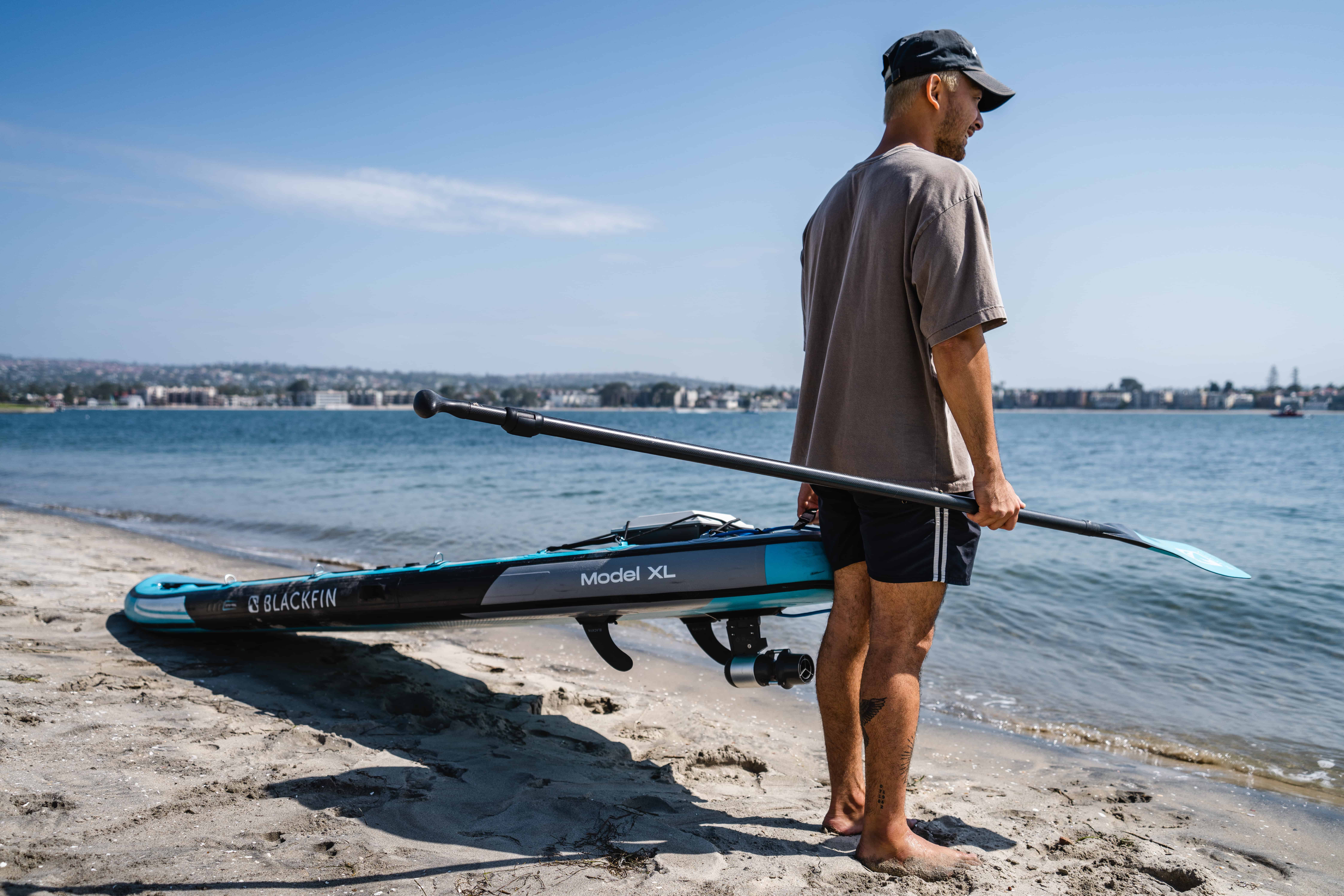 Man getting ready to take paddle board out with DIY fin adapter