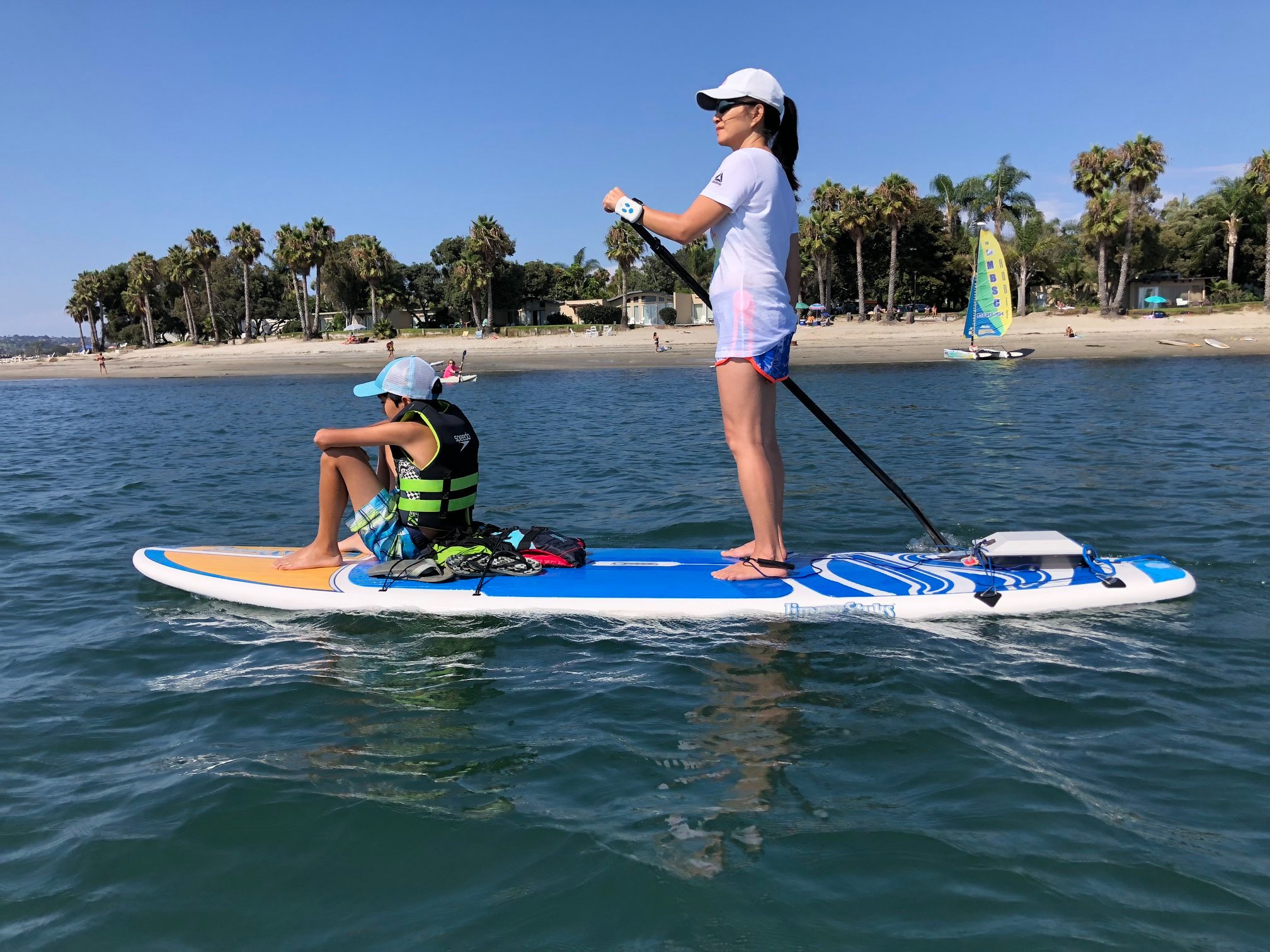 Mom and child paddleboarding together with Bixpy motor