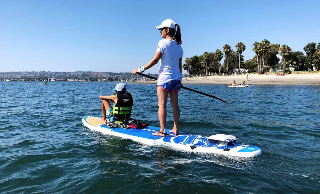 Mom and child on stand up paddleboard motorized by Bixpy