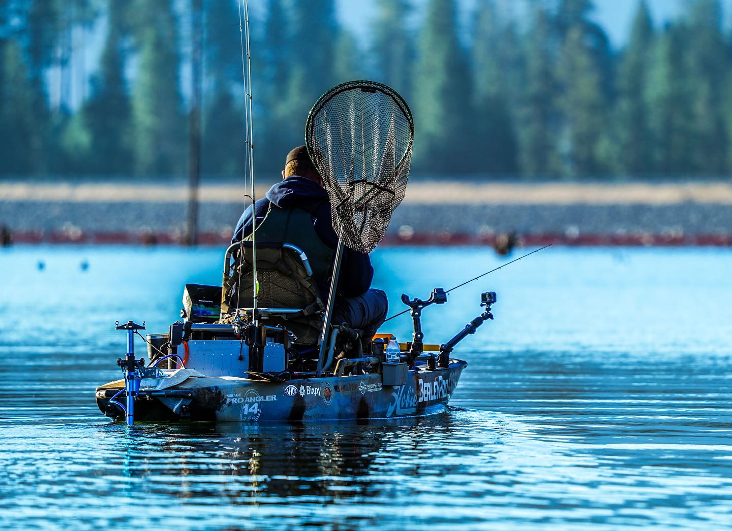 Man in kayak with Bixpy motor heading out to fishing spot