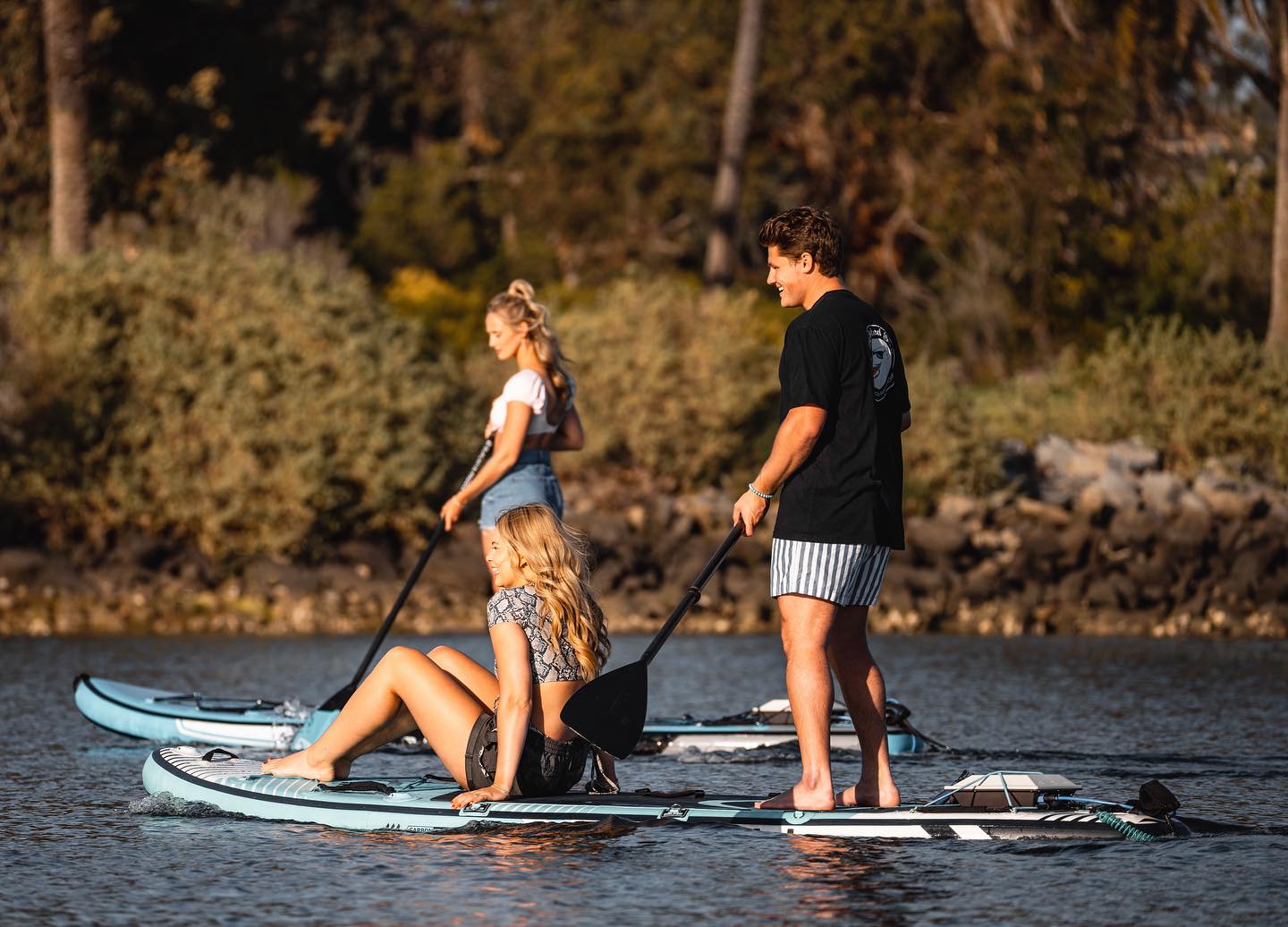 Three people on separate paddleboards using Bixpy motors