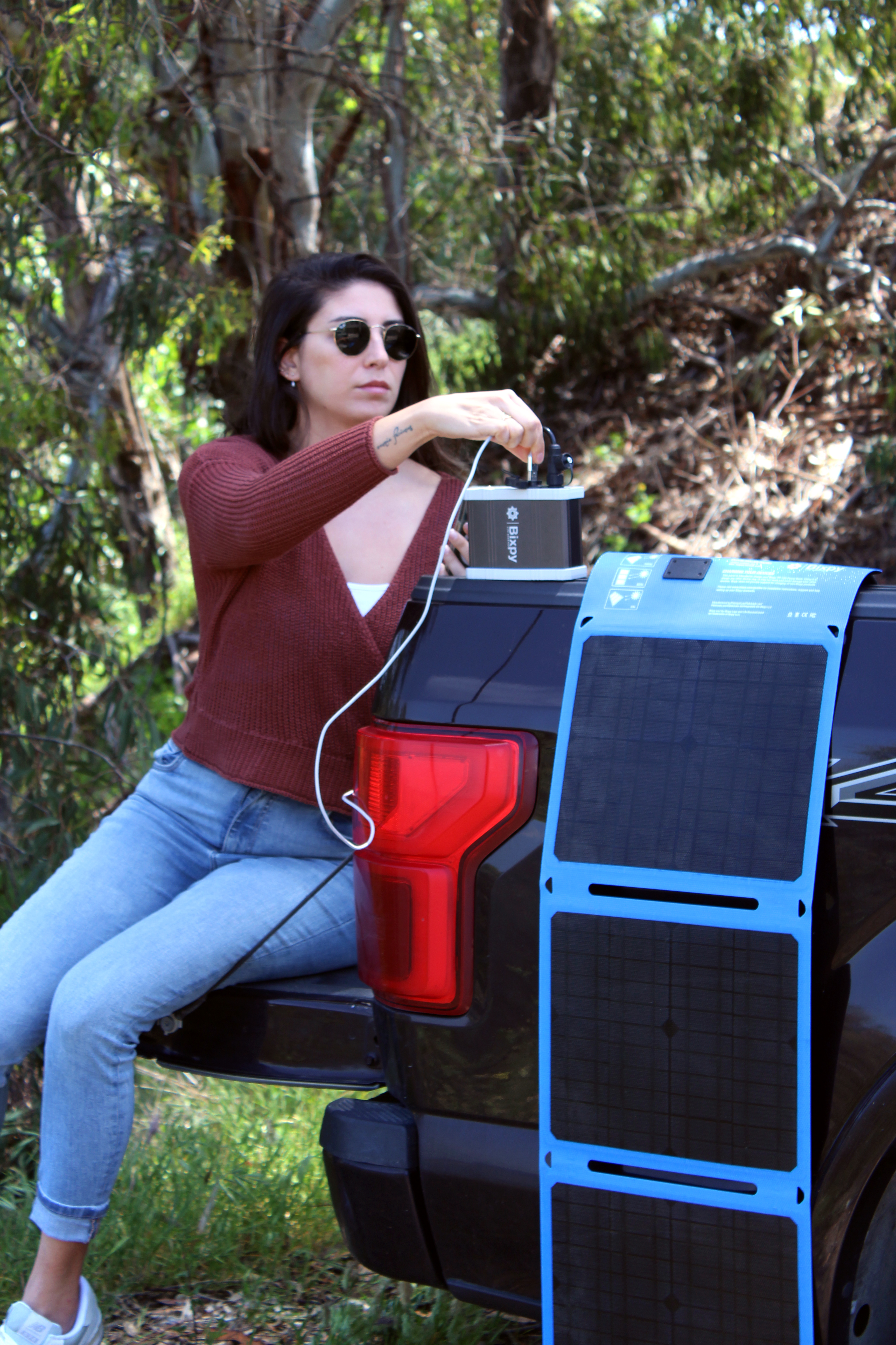 Woman using Bixpy power bank with solar panel chargers